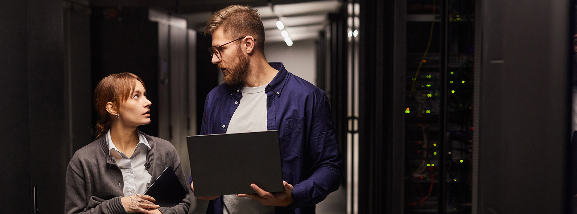 Two people in a data center discussing technology